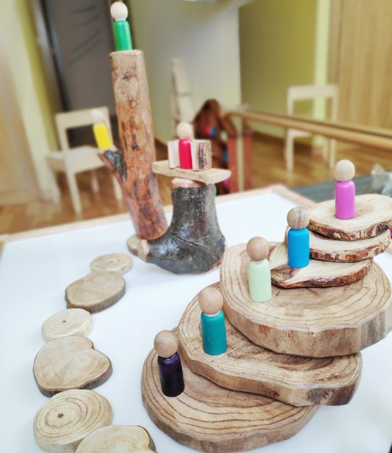 minimundo con nins y rodajas de madera reggio montessori